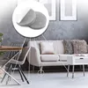 Close-up view of round, self-adhesive felt pads applied to the legs of furniture in a living room setting. Produktbild-Vorschau