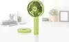 A green portable fan and its stand are shown on a desk with office supplies in the blurred background. Anteprima dell’immagine prodotto