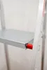 A close-up view of a step on an aluminum ladder, showing a red locking mechanism. Anteprima dell’immagine prodotto