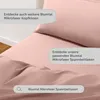 A close-up view of pink bedding, with text overlays highlighting product features and related items. Voir les images du produit