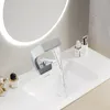 A modern bathroom sink with a waterfall faucet running. Podgląd zdjęcia produktu