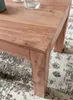 A close-up view of a wooden coffee table leg and its surface, resting on a patterned rug. Náhled obrázku produktu