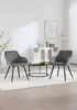 Two dark gray upholstered chairs with black metal legs are placed on a white rug in a room with white paneled walls and a white cabinet in the background. Produktbild-Vorschau