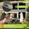 Two children are interacting with a rabbit in a two-story hutch outdoors. Produktbild-Vorschau