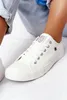 A close-up shot of a person's foot wearing a white sneaker. Podgląd zdjęcia produktu