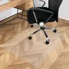 An office chair mat on a wooden floor next to a desk. Náhled obrázku produktu