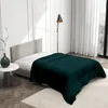 A bedroom scene with a bed covered in a dark green blanket. Produktbild-Vorschau