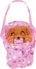 A plush toy dog in a pink carrier with rainbow and flower patterns. Produktbild-Vorschau