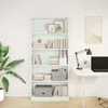 A white bookshelf filled with books and decorative items, placed in a room with a desk and a plant. Produktbild-Vorschau