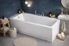 A modern bathroom with a white bathtub, sink, and blue tiled walls. Produktbild-Vorschau