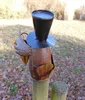 A metal garden decoration shaped like a raven wearing a hat, mounted on a wooden post in an outdoor setting with fallen leaves. Produktbild-Vorschau