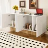 A white sideboard with wooden accents is shown in a room with a patterned rug and artwork on the wall. Náhľad obrázku produktu