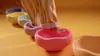 A child's feet in striped pajamas stepping into a line of colorful, pastel-colored balancing stones. Anteprima dell’immagine prodotto