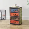A multi-drawer chest with a vintage industrial design sits on a wooden floor next to a framed picture. Anteprima dell’immagine prodotto