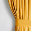 A close-up view of a mustard yellow curtain with pleats and a tie-back. Produktbild-Vorschau