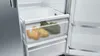 A close-up view of the interior of a refrigerator, showing produce in a clear drawer. Náhled obrázku produktu