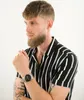 A man wearing a striped shirt and a watch. Podgląd zdjęcia produktu