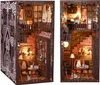 Two views of a miniature DIY book nook kit depicting a cozy, multi-level room with bookshelves, furniture, and decorative elements. Voir les images du produit