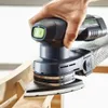 A hand is holding a Festool Akku-Deltaschleifer DTSC 400 3,0 I-Plus and sanding a wooden surface. Voir les images du produit