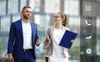 Two business professionals walking and talking outdoors, with icons on the right side of the image. Produktbild-Vorschau