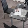 A dining set with black chairs and a glass-top table. Podgląd zdjęcia produktu