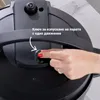 A hand is shown pressing a button on a black pressure cooker lid. Anteprima dell’immagine prodotto