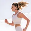 A woman is running outdoors, wearing earbuds. Produktbild-Vorschau