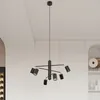 A modern black chandelier hangs from the ceiling in a well-lit room with white walls and cabinets. Podgląd zdjęcia produktu