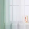 A close-up view of sheer curtains with a green-to-white gradient, partially obscuring a window and a framed picture on a shelf. Produktbild-Vorschau