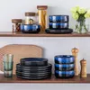 A collection of tableware and kitchenware items arranged on two shelves against a white wall. Voir les images du produit