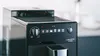 Close-up of a black coffee machine with silver accents. Produktbild-Vorschau