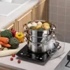 A multi-tiered steamer pot filled with food sits on an induction cooktop, surrounded by fresh vegetables. Voir les images du produit