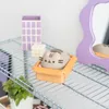 A Pusheen figurine sits in a small orange box on a wire shelf, with other decorative items in the background. Produktbild-Vorschau