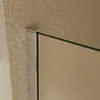 A close-up view of a shower wall corner, showing the glass edge and metal frame against a textured wall. Produktbild-Vorschau