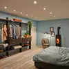 A bedroom scene with a wardrobe, bed, and a wood-burning stove. Produktbild-Vorschau