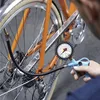 A person is using a tire pressure gauge to inflate a bicycle tire. Náhľad obrázku produktu