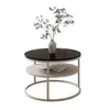 A round, two-tiered coffee table with a black glass top and a light gray base, decorated with a vase of greenery. Produktbild-Vorschau