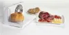 A white electric slicer with a loaf of bread on it, and a plate of sliced meats and cheese next to it. Produktbild-Vorschau