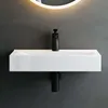 A modern white rectangular sink with a black faucet mounted on a dark gray wall. Produktbild-Vorschau