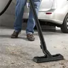 A person is vacuuming a concrete floor with a vacuum cleaner. Produktbild-Vorschau