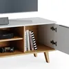 A close-up view of a modern white and wood TV stand with an open cabinet revealing books and a black electronic device. Náhľad obrázku produktu