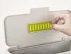 A hand is shown interacting with a green slotted component on the lid of a gray compost bin. Náhled obrázku produktu