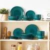 A collection of teal-colored ceramic dishes arranged on shelves. Produktbild-Vorschau