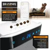 A close-up of a Brandson heater with a remote control and a person relaxing in the background. Produktbild-Vorschau