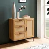 A modern wooden sideboard with rattan accents is shown in a room with a teal wall and a window. Produktbild-Vorschau