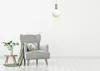 A minimalist interior scene with a gray armchair, a small side table with a plant, and a pendant light. Voir les images du produit