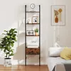 A ladder bookshelf is shown against a white wall, next to a sofa and a large potted plant. Podgląd zdjęcia produktu