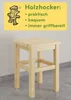 A wooden stool is shown in front of a light gray wall, with a yellow banner containing text and a cartoon character above it. Produktbild-Vorschau