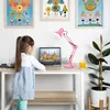 A young girl stands at a desk with a laptop and a pink desk lamp. Anteprima dell’immagine prodotto