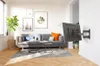 A modern living room with a sofa, coffee tables, and a TV mounted on the wall. Anteprima dell’immagine prodotto